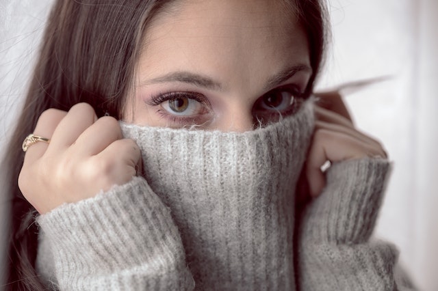 What does it mean when a girl covers her mouth with her hands?